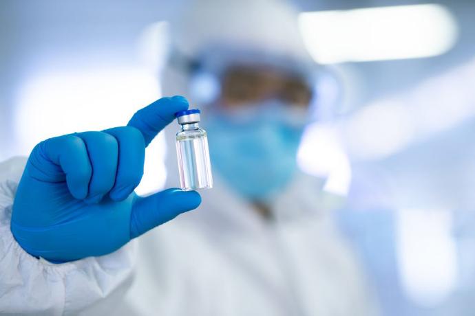 A scientist holding a pharmaceutical vial.